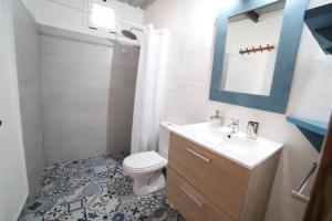 a bathroom with a toilet and a sink and a mirror at La Tierrua home in Tefía +11 photos