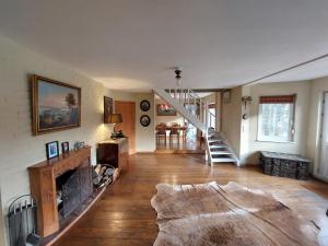 ein Wohnzimmer mit Kamin und Treppe in der Unterkunft La maison du lac in Cul-des-Sarts