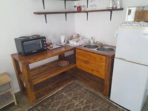 a small kitchen with a sink and a microwave at Weskus Wonderlus - Velddrif in Velddrif