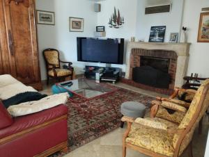a living room with a fireplace and a tv at Maison Familiale in Allonnes