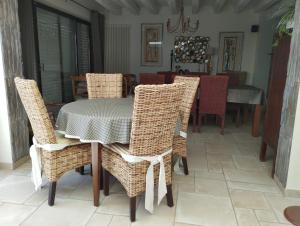 a dining room with a table and wicker chairs at Maison Familiale in Allonnes