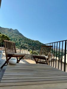 two wooden chairs sitting on a boardwalk with a view at Villa Casa Savelli in Corbara