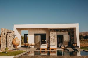 a villa with a swimming pool and a house at Aphrodite Luxury Suites with private heated pools in Kos Town