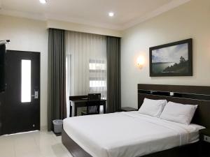 a bedroom with a large bed and a table in it at Selorejo Resort Mitra RedDoorz in Sekar