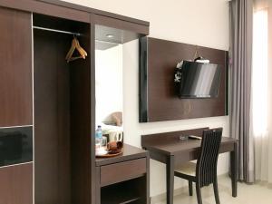 a room with a desk and a tv on the wall at Selorejo Resort Mitra RedDoorz in Sekar