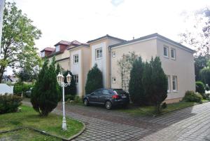 ein schwarzes Auto, das vor einem Haus geparkt ist in der Unterkunft Fewo Rosenhof 13 in Kühlungsborn