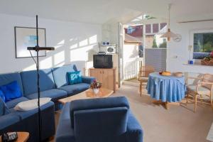 ein Wohnzimmer mit einem blauen Sofa und einem Tisch in der Unterkunft Fewo Rosenhof 16 in Kühlungsborn