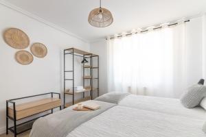 a white bedroom with a bed and a shelf at La Casuca de Barcena in Bárcena