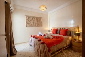una camera da letto con un letto con due animali di peluche sopra di Aliya Luxury Apartment - CORAIL - AGADIR ad Agadir