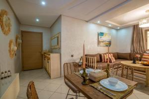 un soggiorno con un tavolo e un divano di Aliya Luxury Apartment - CORAIL - AGADIR ad Agadir