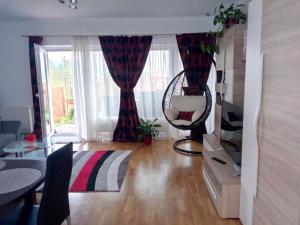 een woonkamer met een tafel en een stoel voor een raam bij VDK Apartament Swiss Village in Sibiu