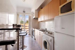 アルマカオ・デ・ペラにあるApartamento De La Praia - Armaçãoのキッチン(白い冷蔵庫、食器洗い機付)