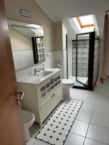 a bathroom with a sink and a toilet and a mirror at Dúplex con vistas al mar in Baiona