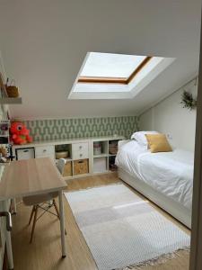 a bedroom with a bed and a skylight at Dúplex con vistas al mar in Baiona
