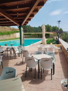 TalarnにあるLas mejores vistas de Talarnのスイミングプールの隣にテーブルと椅子付きのパティオ