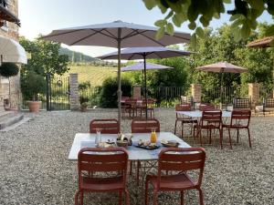 a group of tables and chairs with umbrellas at La Corte Nascosta Volpedo in Volpedo