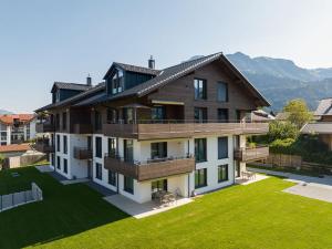 a large house with a large yard with green grass at Villa Alpjuwel in Oberstdorf