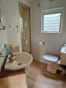 a bathroom with a sink and a toilet and a window at Helove Domki Karoliny in Hel +28 photos