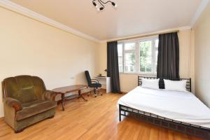 a bedroom with a bed and a chair and a desk at Cozy appartement in big center in Yerevan