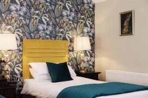 a bedroom with a bed with a floral wallpaper at Corbett Court in Fermoy