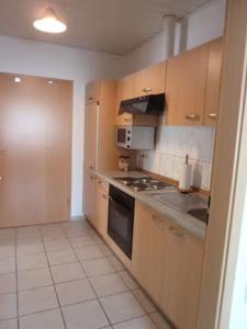 a kitchen with wooden cabinets and a stove top oven at Barrierefreie Ferienwohnung in Borkum