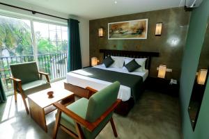 a hotel room with a bed and a balcony at Riviera Tide in Bentota +70 photos