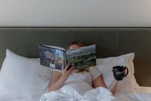 a woman laying in bed reading a book at The Lodge at Jackson Hole in Jackson