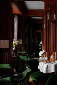 a dining room with green chairs and a table at La Chambre du Marais in Paris +47 photos