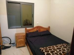 une chambre avec un lit, une fenêtre et un miroir dans l'établissement Appartement pour famille, à Agadir