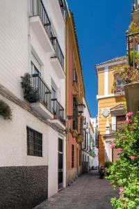 un vicolo in una città con edifici di San Isidoro Cathedral Suite by Valcambre a Siviglia
