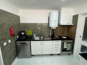 a kitchen with a sink and a counter top at Beachfront Amazing Location - 19th Hole in Ponta Delgada +19 photos