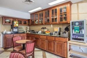 a kitchen with wooden cabinets and a table with chairs at Quality Inn Waynesboro in Waynesboro