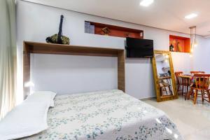 a bedroom with a bed and a dining room at Aconchego em sampa in Sao Paulo