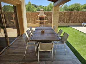 a wooden table and chairs on a patio at Utopia in Puigventos