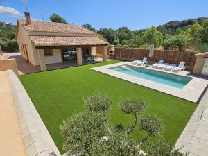 a garden with a swimming pool and a house at Utopia in Puigventos