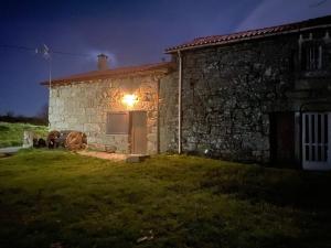a stone house with a light on the side of it at Casa Quintas dos Mouros in Montederramo