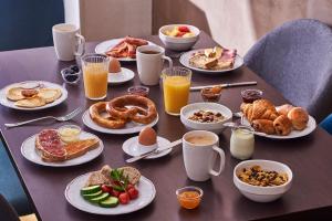 a table with plates of breakfast food on it at Hôtel de l'Europe by HappyCulture in Strasbourg