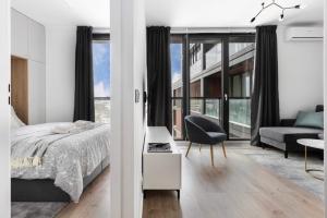 Un dormitorio con una cama, una silla y un sofá. en Dream Team Nordic Haven, en Bydgoszcz