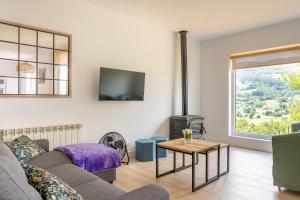 a living room with a couch and a fireplace at La Casuca de Barcena in Bárcena