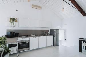 a kitchen with white cabinets and stainless steel appliances at La Casa di Ele in Matera