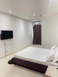a bedroom with a large bed and a flat screen tv at Ixora AP 2 in Ngor