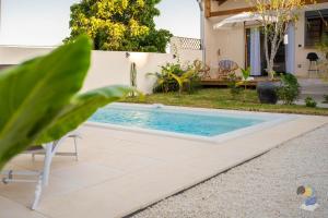 a swimming pool in the backyard of a house at L'oasis 3 étoiles - Lodge 2 - DODOTERLA in Le Tampon +3 photos