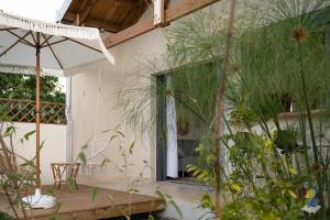 a patio with a table and chairs and plants at L'oasis 3 étoiles - Lodge 2 - DODOTERLA in Le Tampon