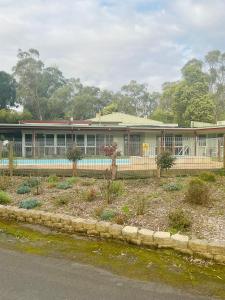 a building with a garden in front of it at Sanctuary House Resort Motel in Healesville