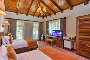 a bedroom with two beds and a flat screen tv at CC Beach Front Papagayo All Inclusive in Culebra