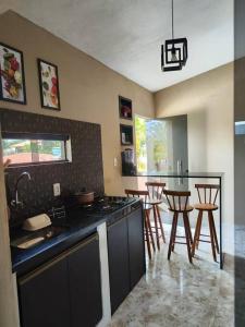 Una cocina con encimera, mesa y sillas. en Flat à beira-mar na praia de Antunes, en Maragogi