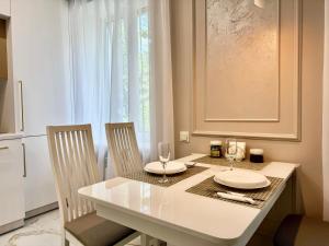 tavolo da pranzo con 2 sedie e tavolo bianco di ApartPoltava NEW PALACE 2023 Вишукані апартаменти на Соборності Центр Готельні чеки a Poltava