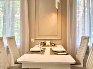 un tavolo con due sedie e un tavolo bianco con bicchieri di ApartPoltava NEW PALACE 2023 Вишукані апартаменти на Соборності Центр Готельні чеки a Poltava Altre 14 foto