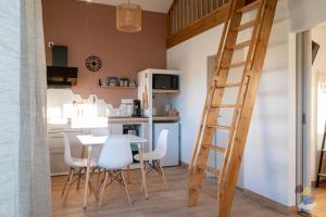 a kitchen with a table and chairs and a ladder at L'oasis - Lodges 3 étoiles - DODOTERLA in Le Onzième