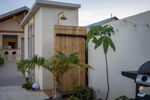 a wooden fence in front of a house with plants at L'oasis - Lodges 3 étoiles - DODOTERLA in Le Onzième